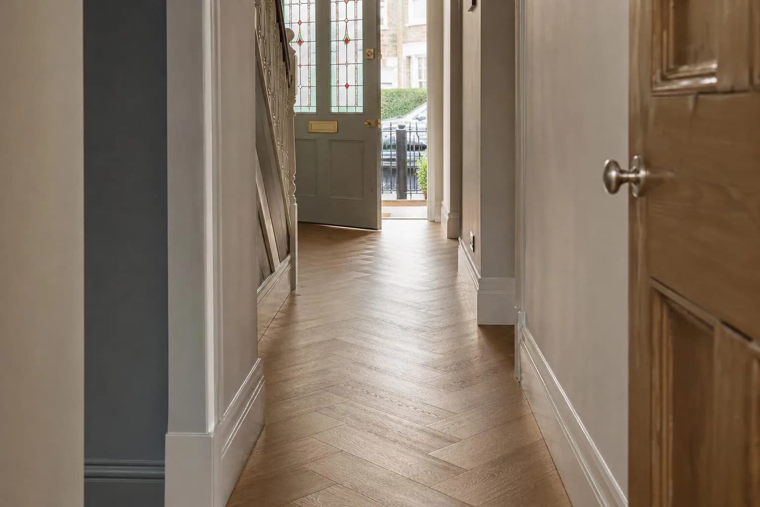 A newly laid herringbone floor running down the hallway of a Victorian terraced house