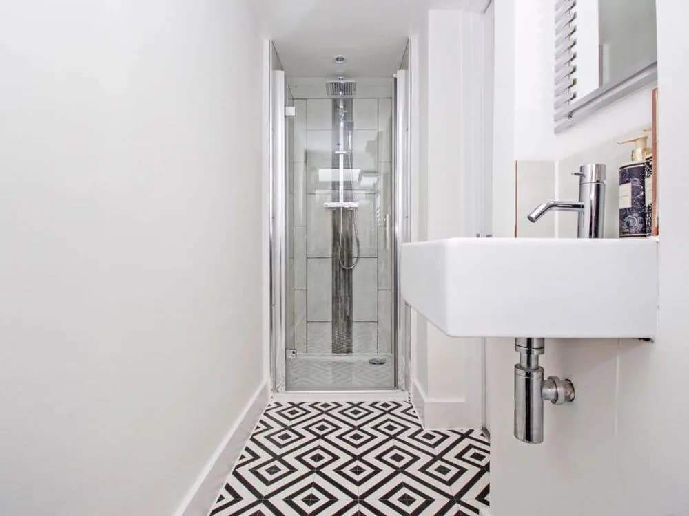 Narrow shower room with a glass screen and a black and white geometric floor
