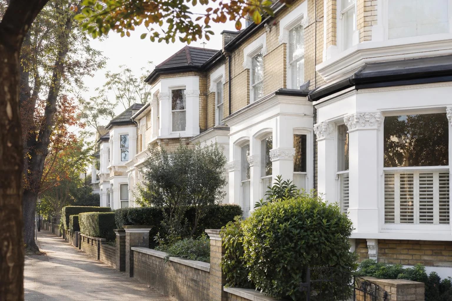 Victorian semi-detached villas with front gardens and mature trees on a leafy suburban road
